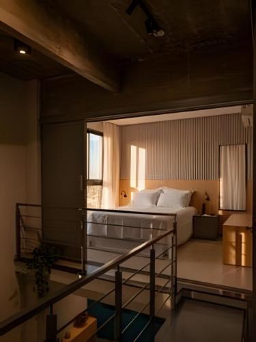 a bedroom with a bed and a balcony with a window at Loft Exclusivo em São Raimundo Nonato - Rooftop com Vista Panorâmica in São Raimundo Nonato