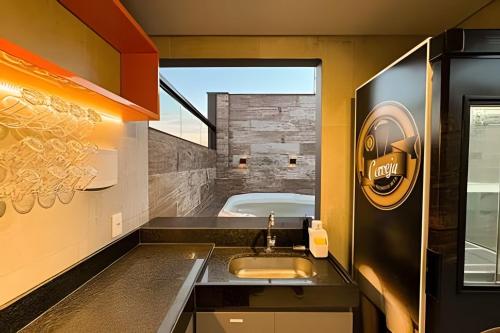 a bathroom with a sink and a bath tub at Loft Exclusivo em São Raimundo Nonato - Rooftop com Vista Panorâmica in São Raimundo Nonato