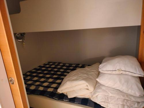 a small bed in a small room with two pillows at Kaksio Kivitipun lähellä in Lappajärvi