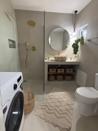 a bathroom with a washing machine and a mirror at Bougainvillea in Asklipiḯon