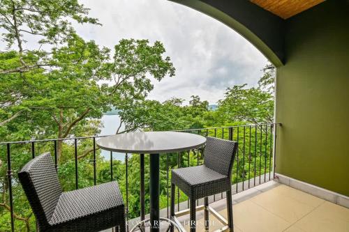 a balcony with two chairs and a table on a railing at 360 Splendor 306-Ocean View Condo-Breakfast in Playa Flamingo