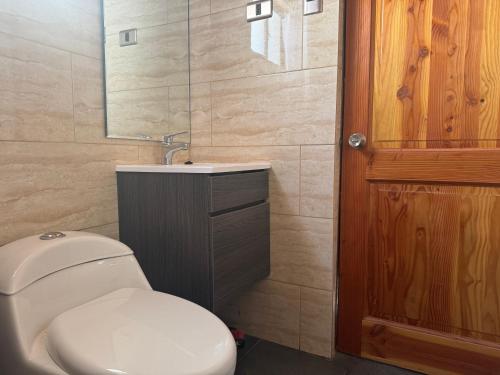 a bathroom with a toilet and a sink and a mirror at conixia in San Pedro de Atacama