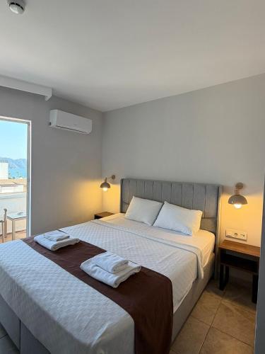 a bedroom with a bed with two towels on it at AViSOS HOTEL & APARTMENTS in Marmaris