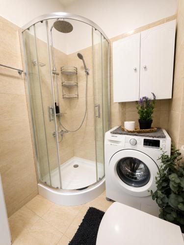 a bathroom with a shower and a washing machine at ROYAL MIRAGE Militari Residence in Chiajna