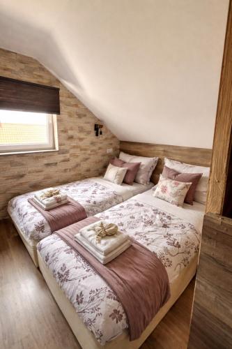 two twin beds in a room with at Csobogó Suites Apartman in Keszthely