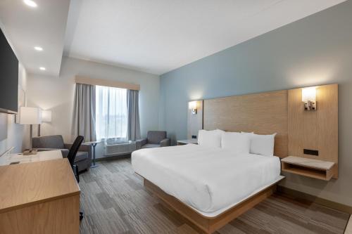 a hotel room with a large white bed and a desk at Best Western Plus Kawartha Lakes Hotel & Suites in Lindsay