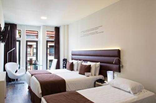 Ένα ή περισσότερα κρεβάτια σε δωμάτιο στο 1881 Barcelona Gran Rosellon Hotel
