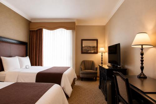a hotel room with two beds and a television at The Inn at UCLA in Los Angeles