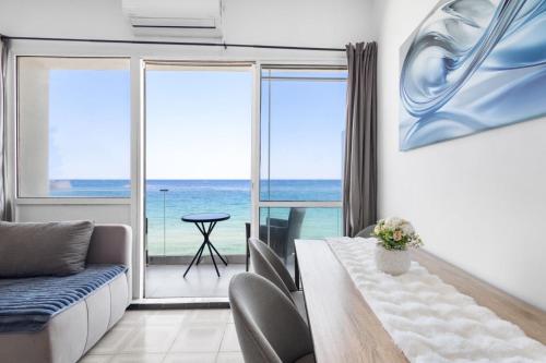 a living room with a table and a view of the ocean at Julies Studios in Chania