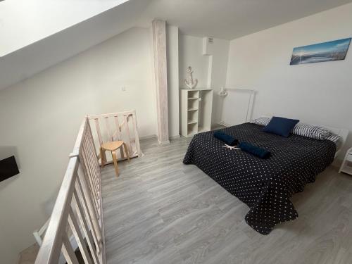 a bedroom with a black bed in a white room at Apartamenty Łuska Rowy in Rowy