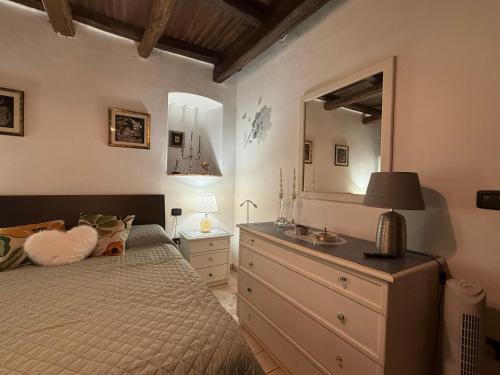 ein Schlafzimmer mit einem Bett und einer Kommode mit Spiegel in der Unterkunft Mameli 27 in Spoleto