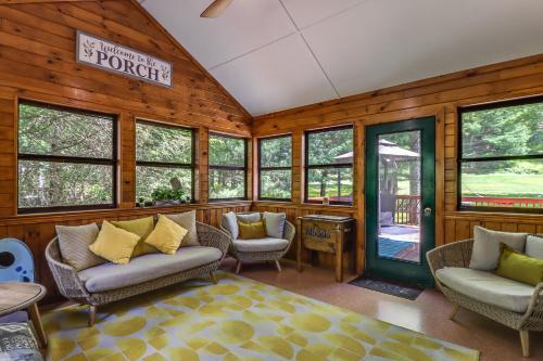 a living room with chairs and windows and a sign at Split Rock Resort: Family Getaway w/ Fire Pit! in Lake Harmony