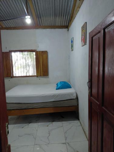 a small room with a bed and a window at Cabaña Colibrí Balgue in Altagracia