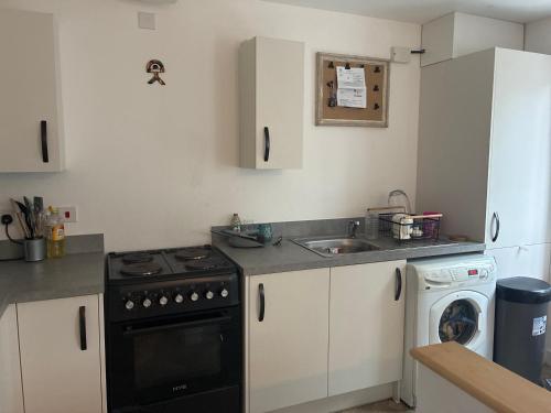 a kitchen with a sink and a stove and a dishwasher at StaywithusHighbridge in Highbridge