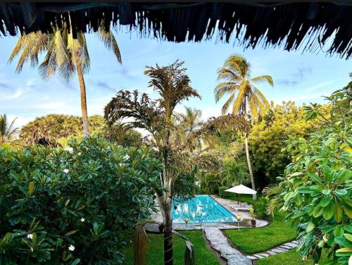 a resort with a swimming pool and palm trees at WHITE Nyumba Malindi - Boutique Villa in Malindi