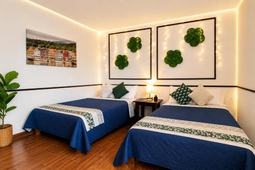 two beds in a hotel room with blue sheets at Nagomi Casa amplia para empresas, grupos y familias in Pachuca de Soto