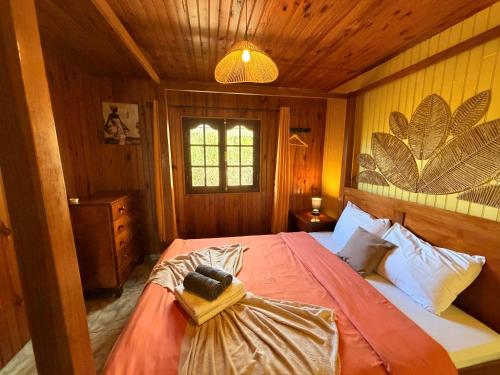 a bedroom with a large bed in a wooden room at Le Taïbit in Cilaos