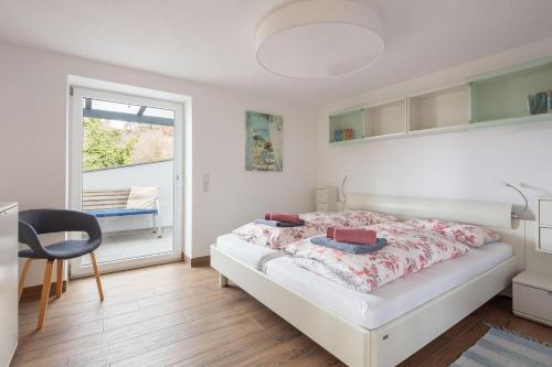 a white bedroom with a bed and a window at Ferienwohnung Süßenmühle Naturstrand in Sipplingen
