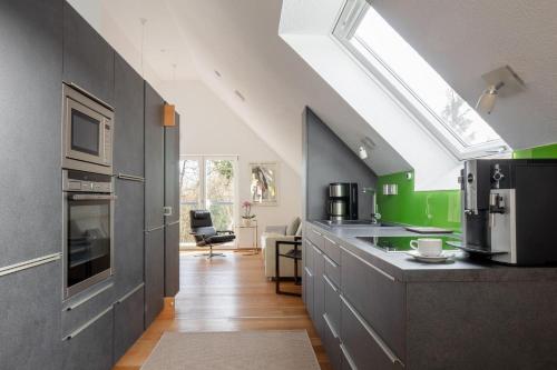 a kitchen with gray cabinets and green walls at Studio Süßenmühle mit viel Privatsphäre, direkt am Naturbadestrand in Sipplingen