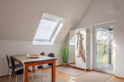 a dining room with a table and chairs and a window at Studio Süßenmühle mit viel Privatsphäre, direkt am Naturbadestrand in Sipplingen