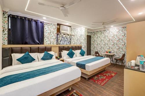 a hotel room with two beds and a table at Family Group with Provide By PG Hotel Near New Delhi Railway station & Karol-Bagh in New Delhi
