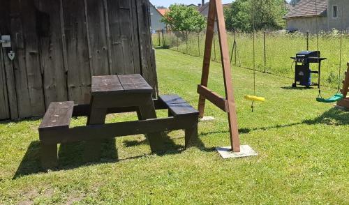 a wooden bench with a swing in a yard at Chata pod vŕškami Važca in Važec