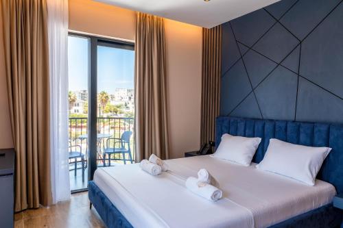 a bedroom with a bed with two towels on it at Zurich Hotel in Ksamil