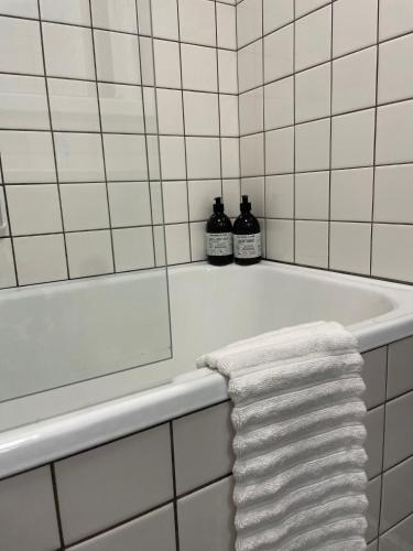 eine weiße Badewanne mit einem Handtuch darauf in der Unterkunft Harbour Living by Jutlandia - Hostel Style in Frederikshavn