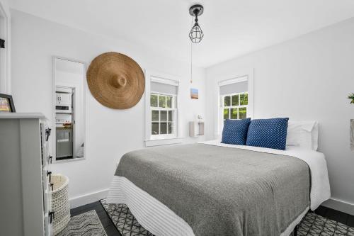 a white bedroom with a large bed with blue pillows at Bed, Splash Beyond – Coastal Comfort Awaits in Orleans