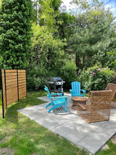 a group of chairs and a grill in a yard at Bed, Splash Beyond – Coastal Comfort Awaits in Orleans