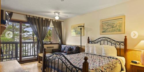 a bedroom with a bed and a balcony at Westwind Inn on the Lake in Buckhorn
