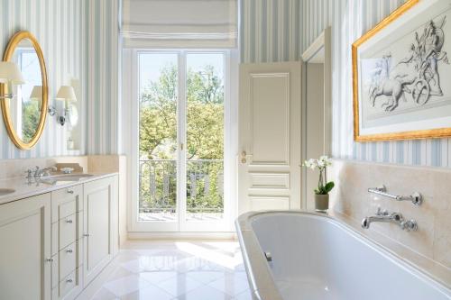 a bathroom with a tub and a window at Brenners Park Hotel & Spa, Oetker Hotels in Baden-Baden