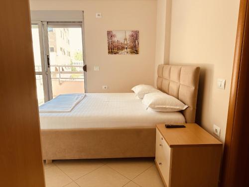 a small bedroom with a bed and a window at Thoma's K Studios in Vlorë