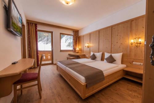 a bedroom with a bed and a desk at Alpenchalet Vital in Neustift im Stubaital
