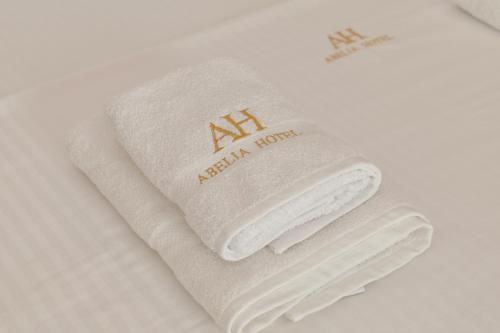 a pair of white gloves sitting on a bed at Abelia Hotel in Ksamil