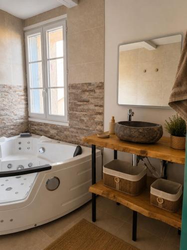 a bathroom with a tub and a sink at Résidence du Soleil & Spa - Collioure in Collioure