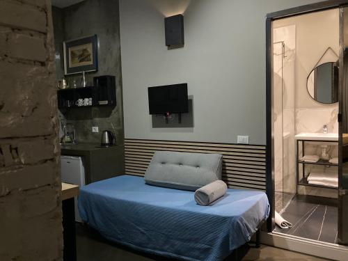 a room with a bed with a chair and a television at Hotel Calypso in Milan