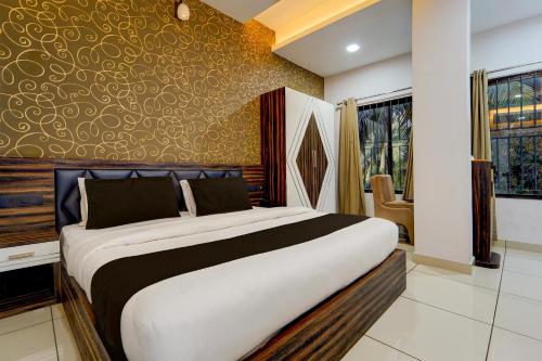a bedroom with a large bed in a room at Hotel O by OYO REFRESH INN & SUITES in Kozhikode