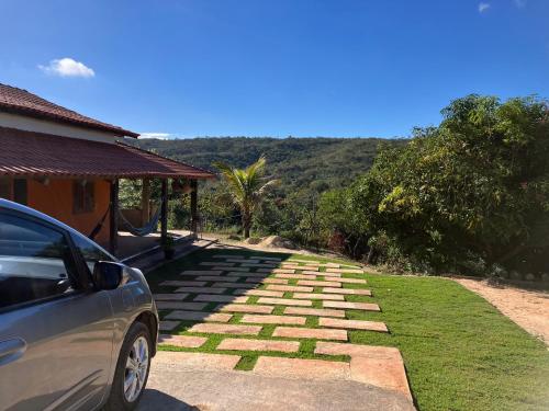 a car parked in front of a house with a stone walkway at Chácara Carvalho in Sabará