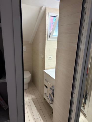 a small bathroom with a toilet and a sink at SnowWhite Home in Porto Ercole