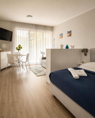 a bedroom with a large bed and a dining room at Apartament typu studio Doris 3 - 50m od plaży in Pobierowo