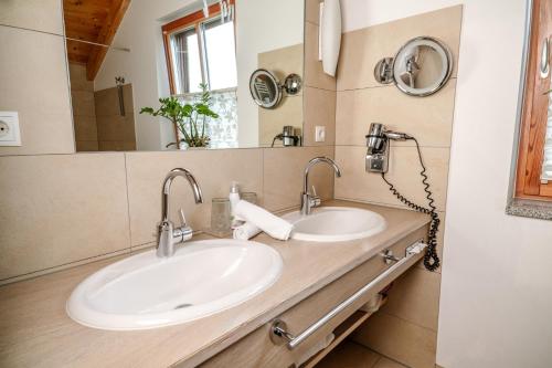 a bathroom with two sinks and a mirror at 5 Sterne Holzchalet Dienberger Hof in Untergriesbach