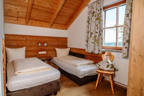 two beds in a room with a window at 5 Sterne Holzchalet Dienberger Hof in Untergriesbach