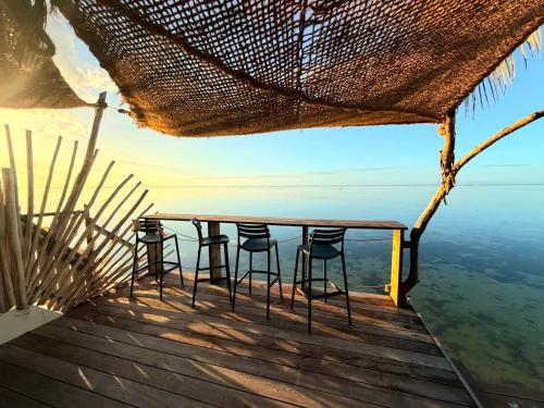 a table and chairs on a deck overlooking the ocean at Secret Spot Lagoon Dream in Moorea