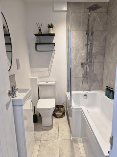 a bathroom with a tub and a toilet and a sink at River Breeze BALCONY 2 in Littlehampton