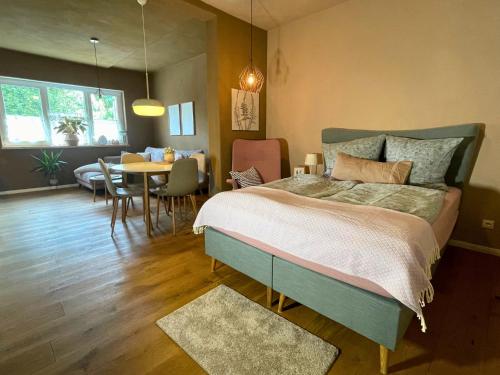 a bedroom with a large bed and a dining room at Kochstedter Wohnstuben - Fewo mit Naturbaustoffen in der Bauhausstadt Dessau - hundefreundlich - ebenerdig - mit Garten - Parkplatz inklusive in Dessau
