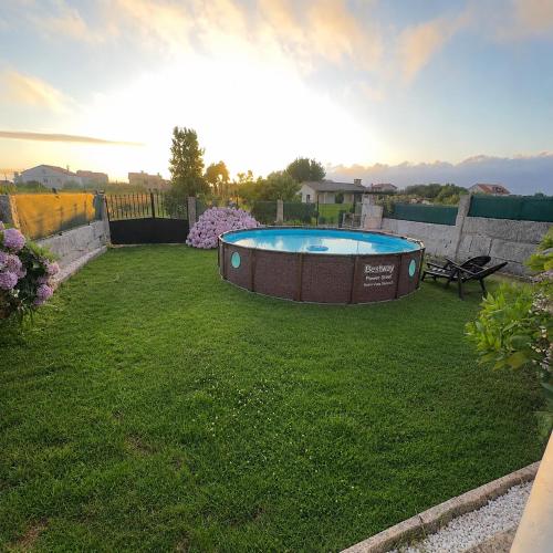 a backyard with a hot tub in the grass at CASA Nieves in O Grove