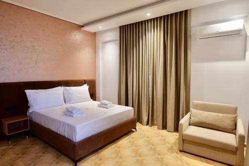 a hotel room with a bed and a chair at Abelia Hotel in Ksamil