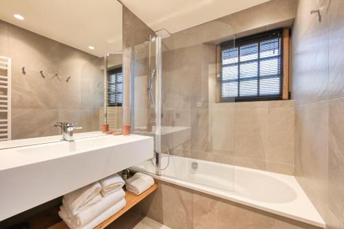 a bathroom with a sink and a tub and a shower at Le Chalet Remy in Saint-Gervais-les-Bains