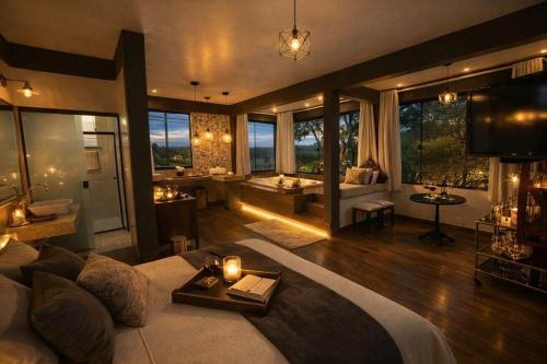 a large living room with a couch and a room with a tub at Solar das Aroeiras in Serra do Cipo